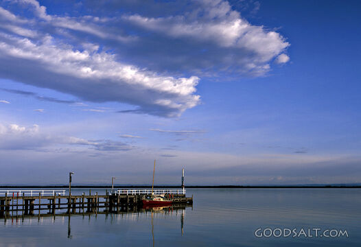 boardwalk over water with fluffy clouds
