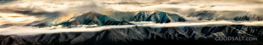 Distant mountains with snow, dramatic skies.