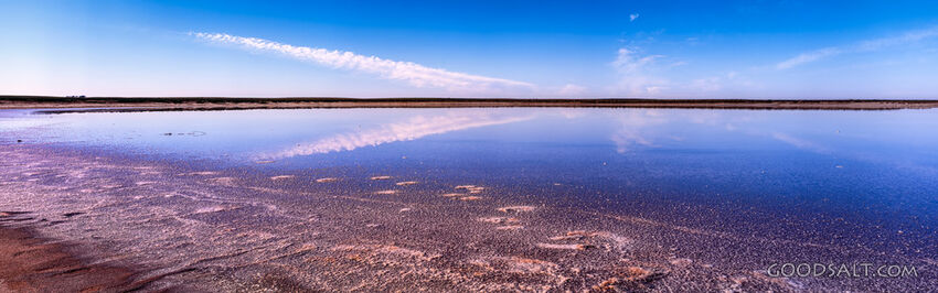 Dramatic sky over inland salt lake from edge.