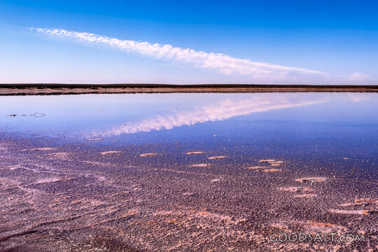 Dramatic sky over inland salt lake from edge.