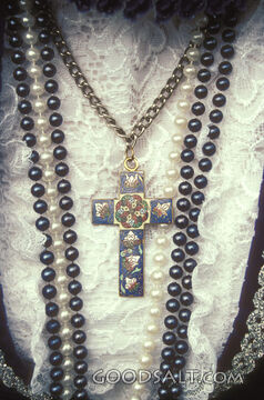 Beads of pearls and a cross necklace on lace.
