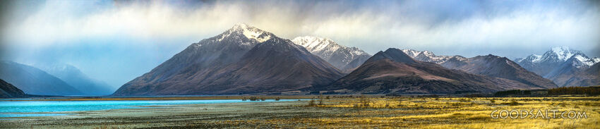 Mountains beside lake with stony shore.