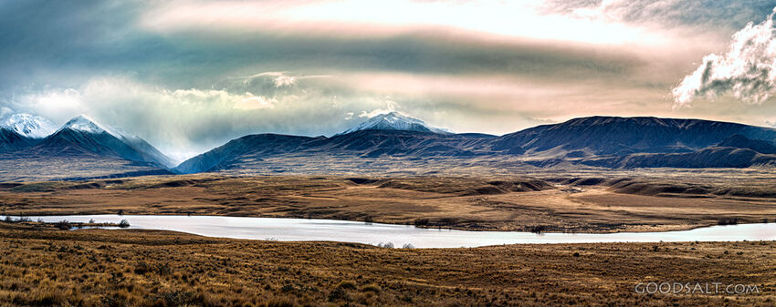 Narrow lake with mountain range.