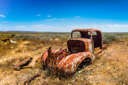 pick-up truck wreck in wide and dry desert surroundings.