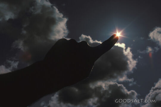 Hand pointing to a star in the sky with clouds surrounding.