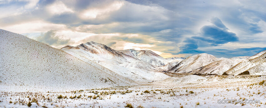 Snow covered mountain range and dramatic cloud effects.