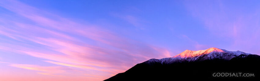 The light of the early sunrise collides with a mountainside.