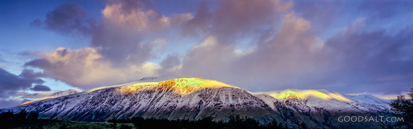 The light of the early sunrise collides with a mountainside.