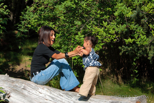 Woman and little girl playing in park.