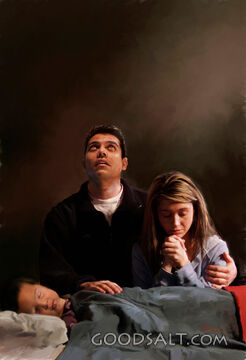 A Father Looks Up As He Prays over Sleeping Son