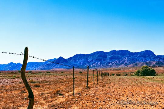 bright blue distant range behind make-do fenc and windmill