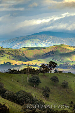 continuous rolling green hills and stormy sky