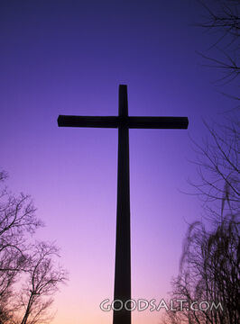 A sunset bhind a dark cross.