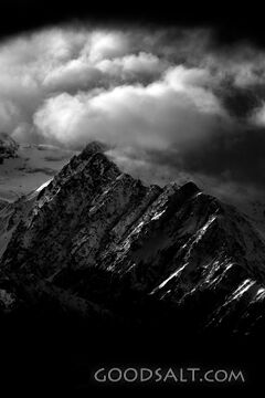 Distant mountains with snow, dramatic skies.