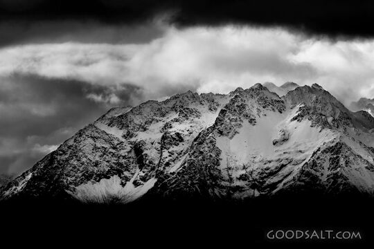 Distant mountains with snow, dramatic skies.