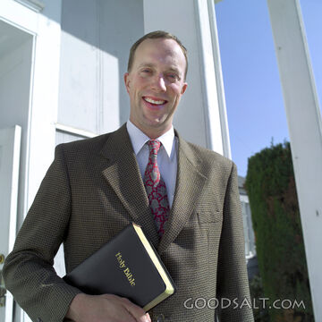 A man in a suit holding the Bible.