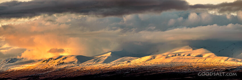 Golden rain shower over snow-covered peaks.