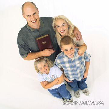 A family looking up and holding a Bible.
