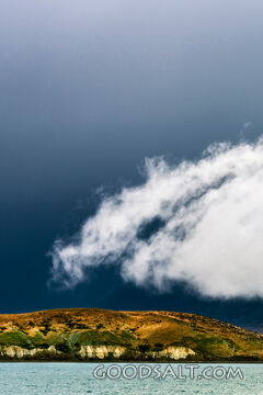 Heavy dark sky behind yellow clay cliffs.
