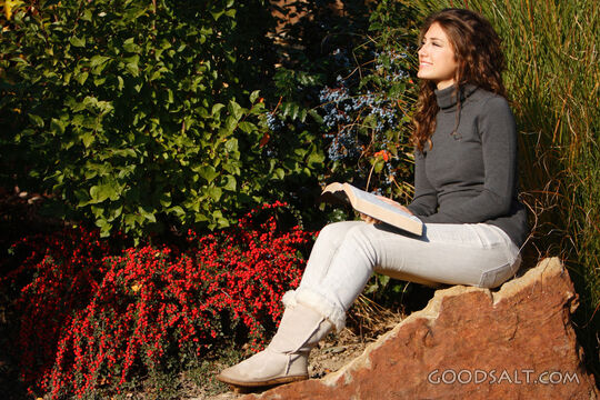 IDAHO. Boise. Young woman reading Bible outdoors (close-up).