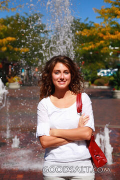 IDAHO. Boise. Young woman smiling in front of fountain.  MR