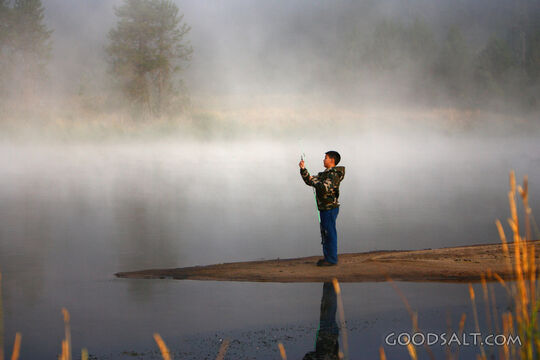 IDAHO. Smith’s Ferry. Boy fishing on foggy morning.