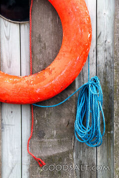 Lifebuoy and Rope on Weathered Dock