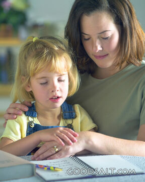 A mother praying with her daughter.