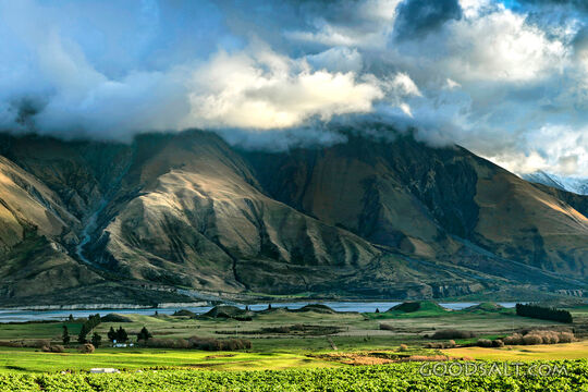 mountain range with green foreground and dramatic lighting