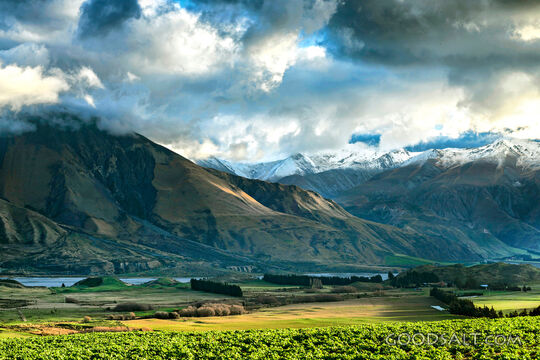 mountain range with green foreground and dramatic lighting