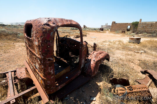 pick-up truck wreck in wide and dry desert surroundings.