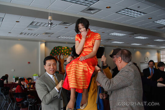 IDAHO. Boise. Asian Jewish girl lifted by her father and gra