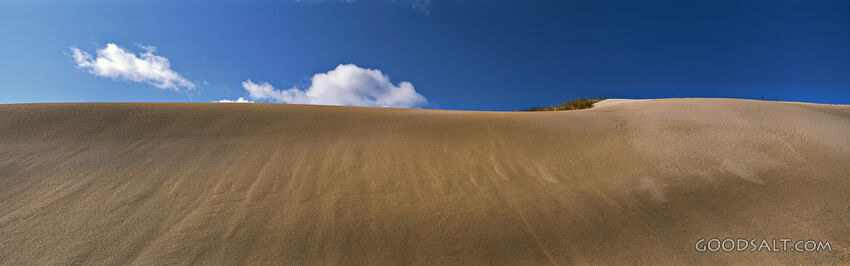 Sand Dune With Blue Sky and Fluffy Clouds