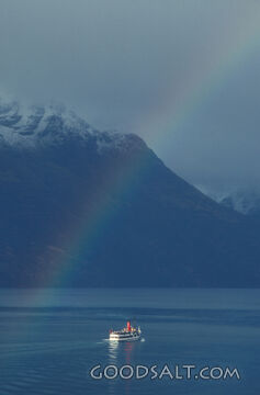 Boat with rainbow above.