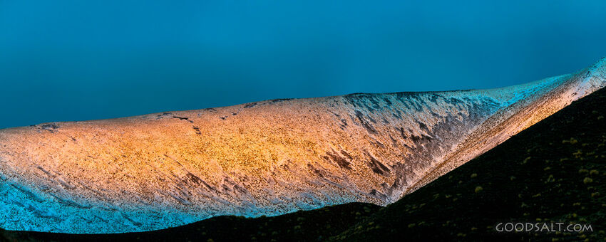 Snowy hill with pink and yellow sun.