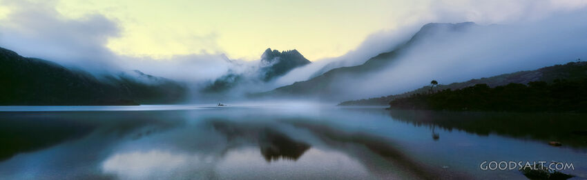 Still reflective lake with heavy pink fog at sunrise.
