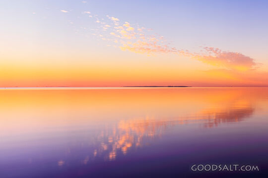 Sunrise on lake with mirror reflections.