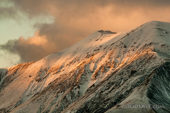 The light of the early sunrise collides with a mountainside.