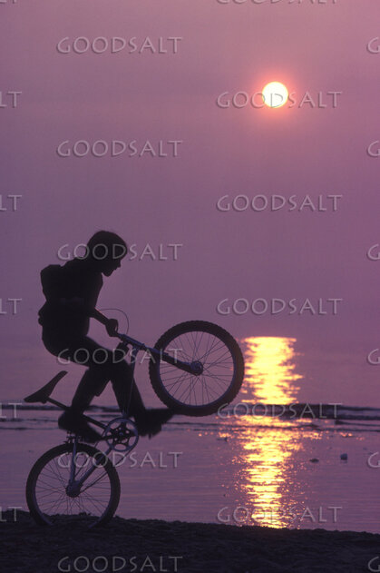 Boy Cyclist at Sunset Shore