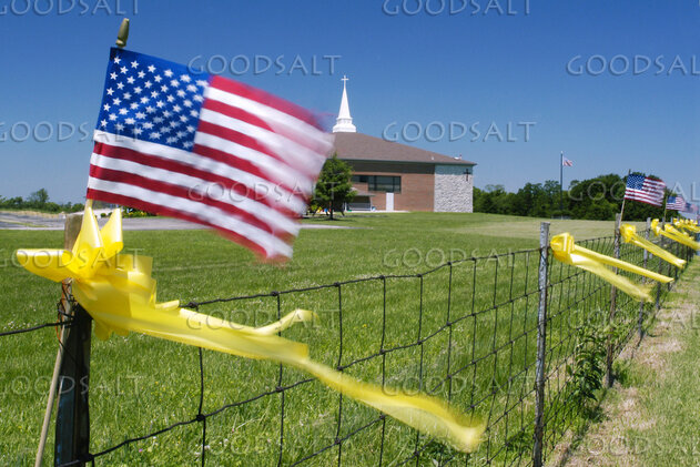 Church Fence with American Flags and Yellow Ribbons