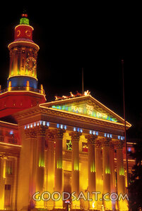 Brightly Lit Building at Night With Santa and Sleigh on Top