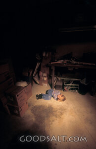 Child in the Shadowed Storeroom