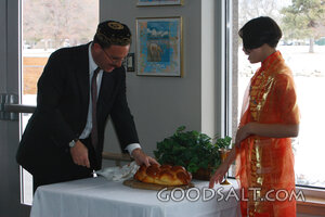 IDAHO. Boise. Rabbi with Asian Jewish girl blessing Challah