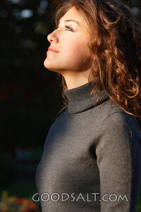 IDAHO. Boise. Young woman looking up into light (close-up).