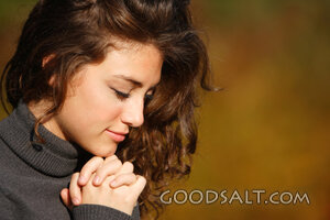 IDAHO. Boise. Young woman praying (close-up). MR
