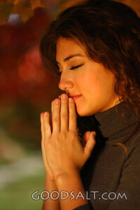 IDAHO. Boise. Young woman praying (close-up). MR