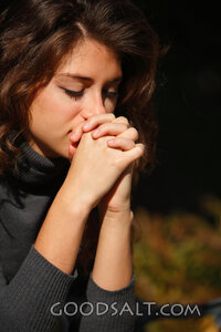 IDAHO. Boise. Young woman praying (close-up). MR