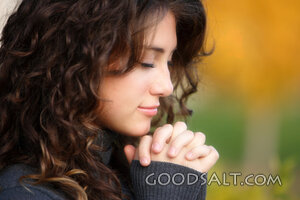 IDAHO. Boise. Young woman praying (close-up). MR