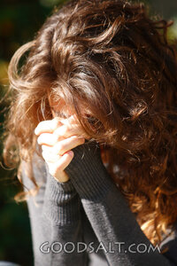 IDAHO. Boise. Young woman praying with face hidden (close-up