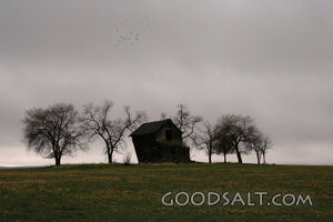 IDAHO. Midvale. Abandoned house against gloomy winter sky in